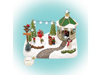 Világító karácsonyi falu, korcsolyázó gyerekekkel